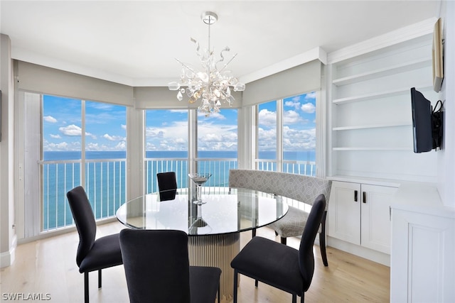 dining area featuring built in shelves, a chandelier, and light hardwood / wood-style floors