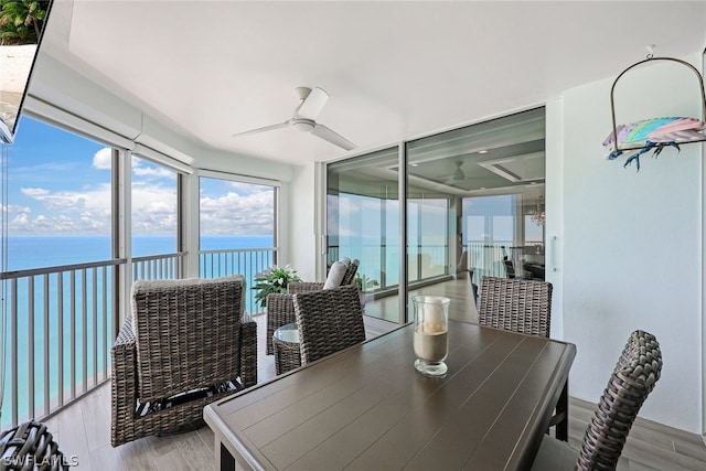 sunroom / solarium with a water view and ceiling fan