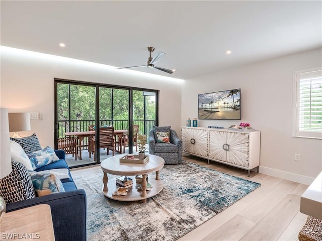 living room featuring ceiling fan and light hardwood / wood-style flooring