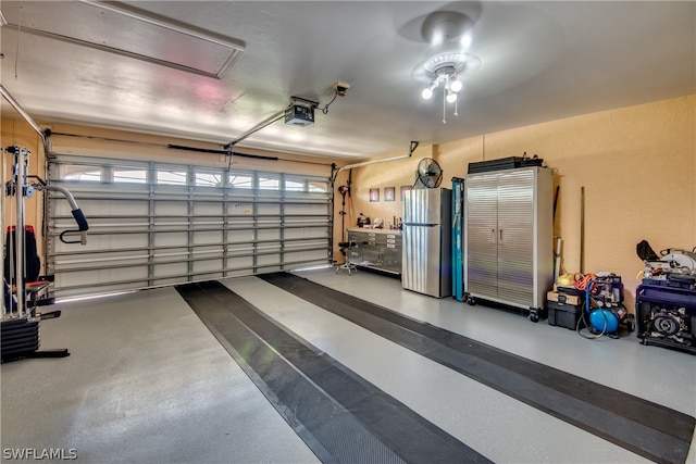 garage with stainless steel fridge and a garage door opener