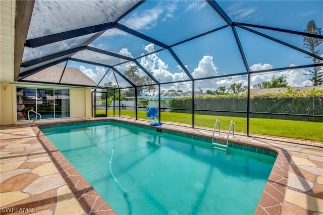 view of pool with a lanai, a patio, and a yard