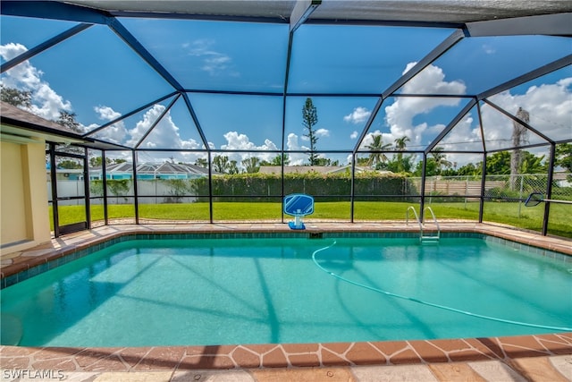 view of swimming pool with glass enclosure and a yard