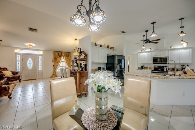 dining area featuring sink, ceiling fan, lofted ceiling, and light tile patterned floors