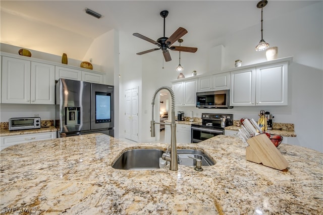 kitchen featuring white cabinetry, ceiling fan, stainless steel appliances, pendant lighting, and sink