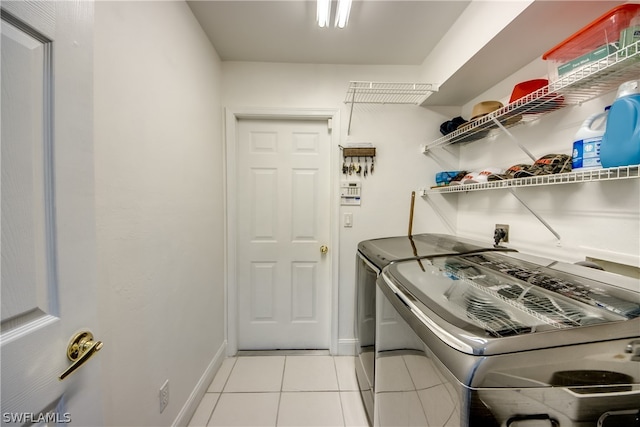 laundry room featuring light tile patterned flooring and washing machine and dryer