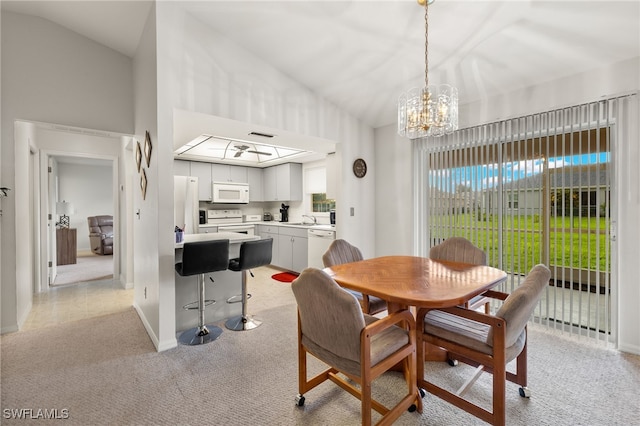 carpeted dining space with a notable chandelier, sink, and high vaulted ceiling