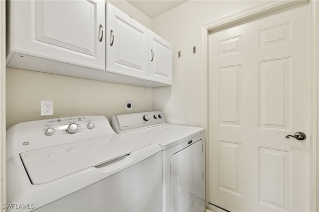 laundry area featuring separate washer and dryer and cabinets