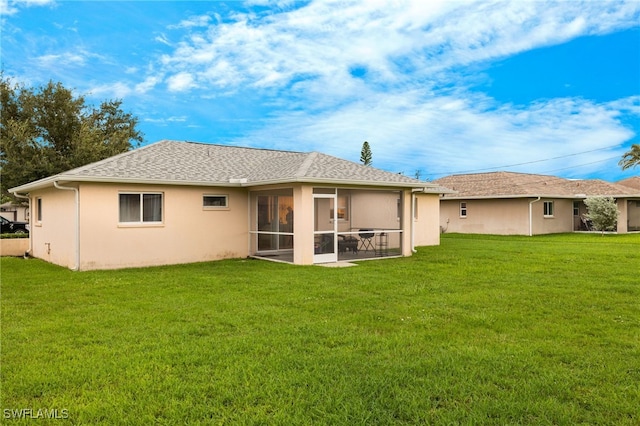 rear view of house with a sunroom and a yard