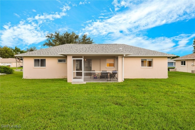 rear view of house with a patio and a lawn