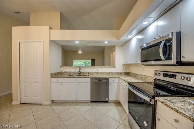 kitchen featuring white cabinets, appliances with stainless steel finishes, ceiling fan, sink, and light stone counters