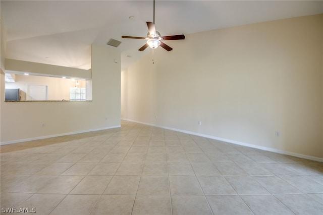 tiled empty room with ceiling fan and vaulted ceiling