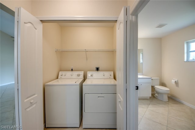 laundry area featuring light tile patterned flooring and washing machine and clothes dryer