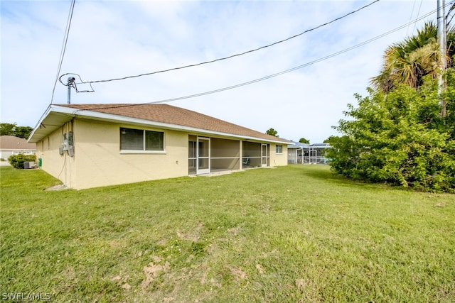 rear view of property featuring a lawn