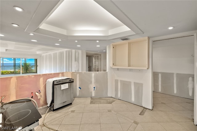 kitchen featuring stainless steel electric stove, a raised ceiling, and light tile patterned flooring