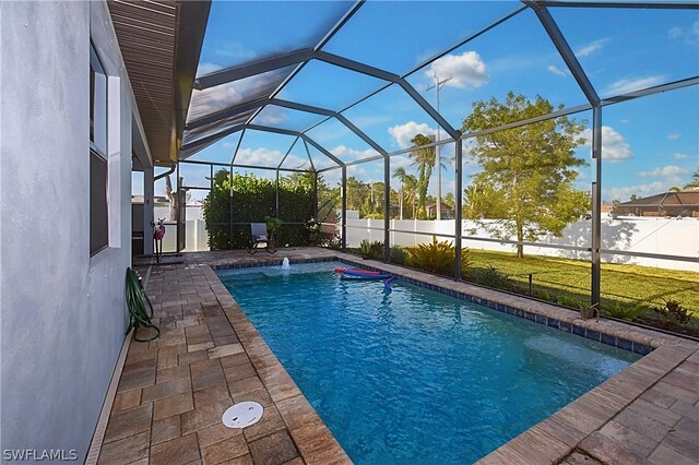 view of pool with a yard, pool water feature, a lanai, and a patio area