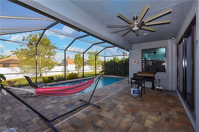 view of patio / terrace featuring glass enclosure, a fenced in pool, and ceiling fan