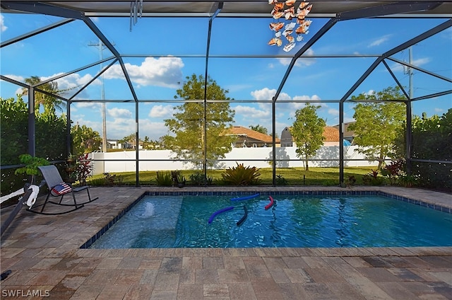 view of swimming pool featuring a lanai and a patio