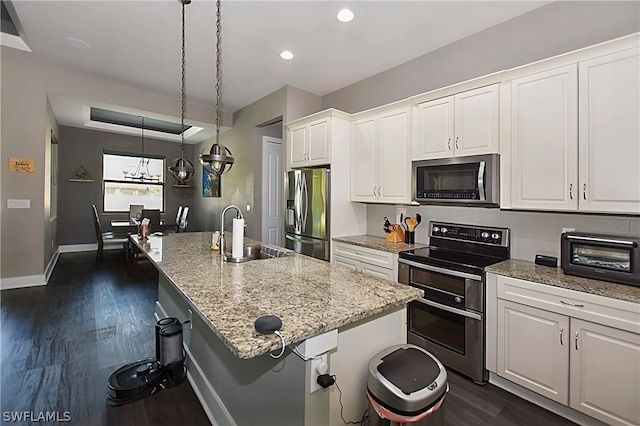 kitchen with a kitchen island with sink, a breakfast bar, stainless steel appliances, sink, and white cabinets