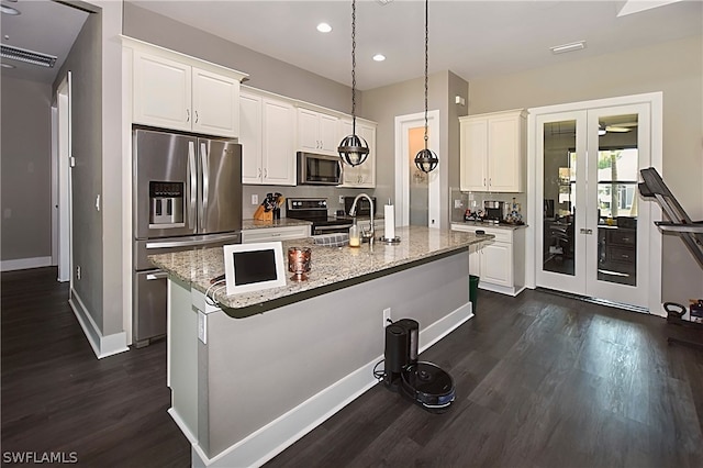 kitchen with white cabinets, appliances with stainless steel finishes, and light stone counters