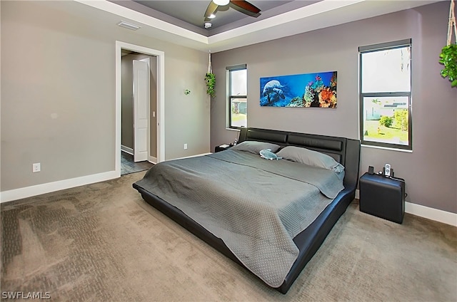 bedroom featuring a tray ceiling, ceiling fan, and carpet flooring