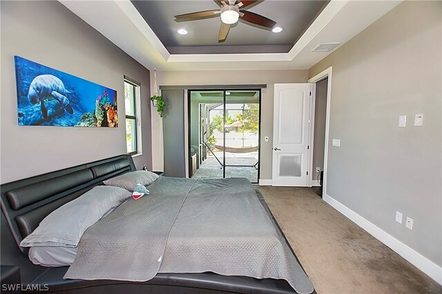 bedroom with access to exterior, ceiling fan, a raised ceiling, and carpet floors