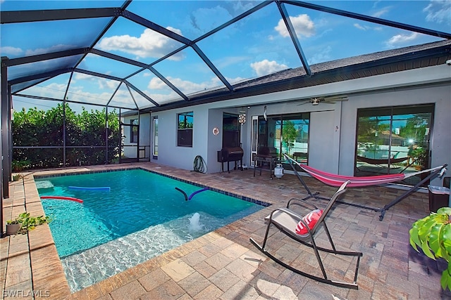 view of pool with a lanai, ceiling fan, and a patio