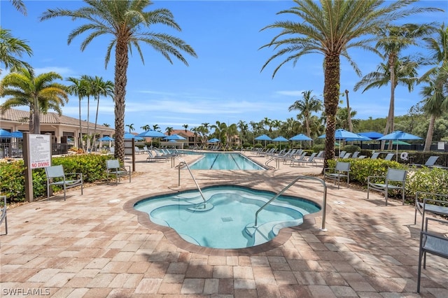 view of pool featuring a patio area and a hot tub