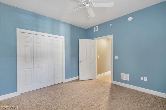 unfurnished bedroom with ceiling fan, light colored carpet, and a closet