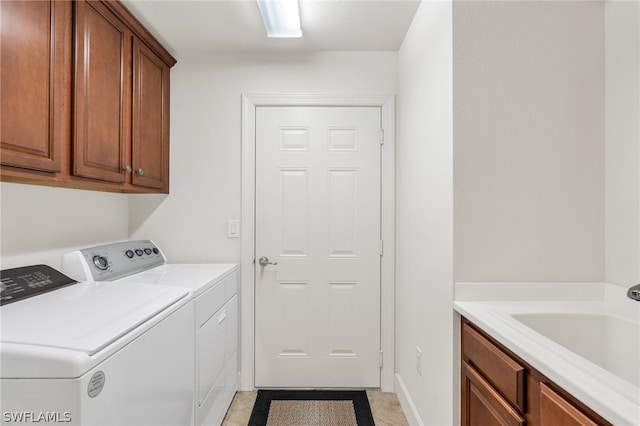 washroom with washer and dryer, cabinets, and sink