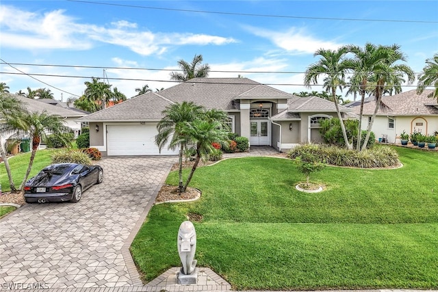 ranch-style house with a garage, a front yard, and french doors