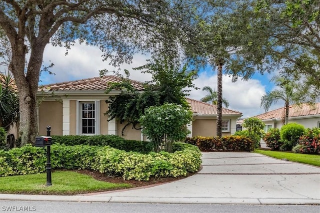 mediterranean / spanish-style home with a tiled roof and stucco siding