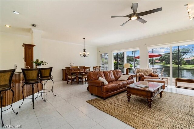 living room featuring light tile patterned floors, ceiling fan with notable chandelier, ornamental molding, and a water view