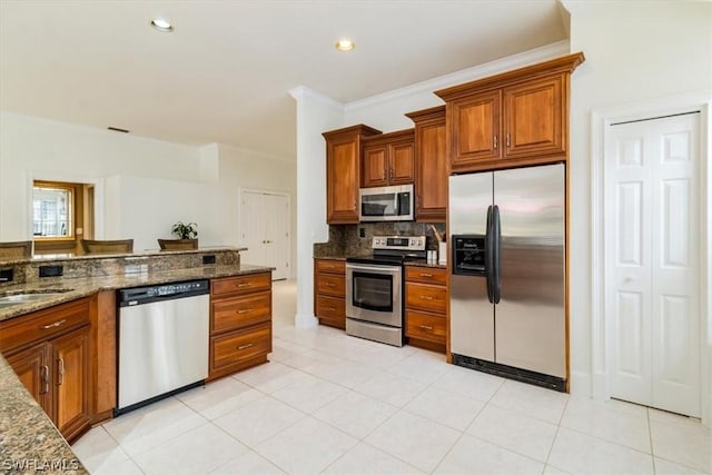 kitchen with stainless steel appliances, brown cabinets, and decorative backsplash