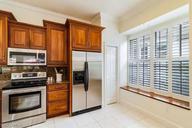 kitchen featuring light tile patterned floors, decorative backsplash, appliances with stainless steel finishes, brown cabinetry, and ornamental molding