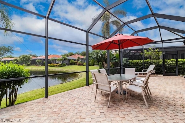 view of patio / terrace featuring a lanai, outdoor dining space, and a water view