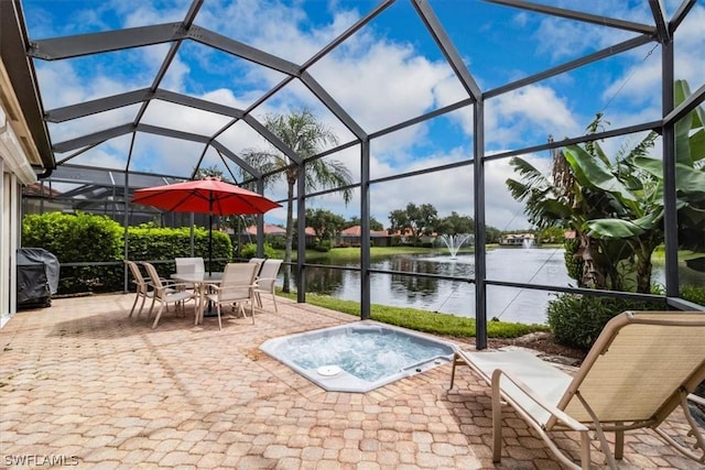 view of patio with glass enclosure and a water view