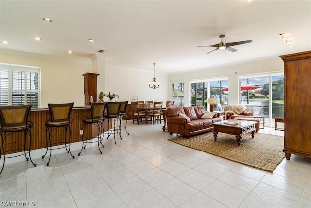 living room with ceiling fan, a healthy amount of sunlight, light tile patterned flooring, and crown molding