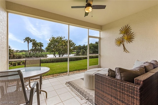 sunroom / solarium with a water view and ceiling fan