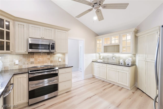 kitchen with stainless steel appliances, backsplash, light hardwood / wood-style flooring, cream cabinetry, and vaulted ceiling