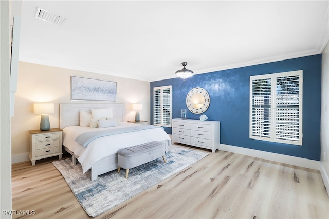 bedroom featuring light hardwood / wood-style floors and crown molding