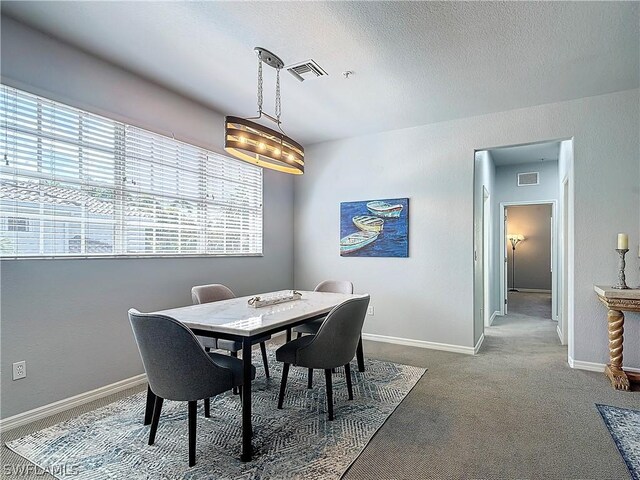 dining space featuring carpet and a textured ceiling