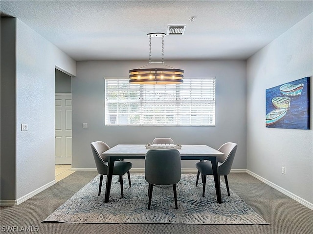 dining area featuring a textured ceiling and carpet