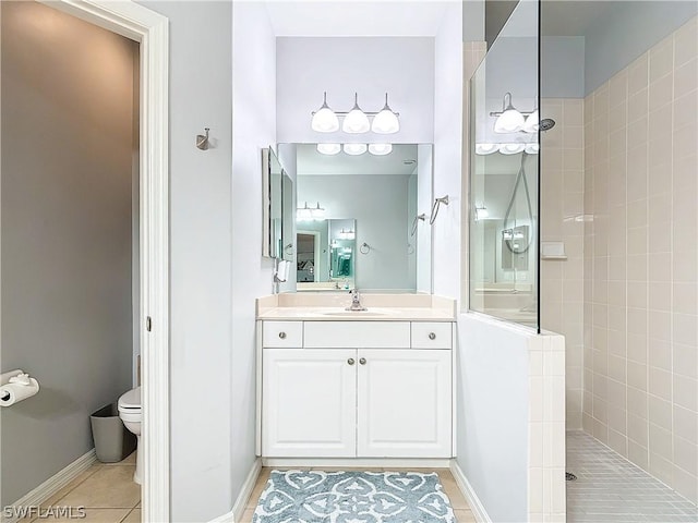 bathroom featuring tile patterned flooring, vanity, toilet, and tiled shower