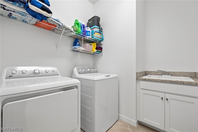 laundry room with washer and clothes dryer, light tile patterned floors, and sink