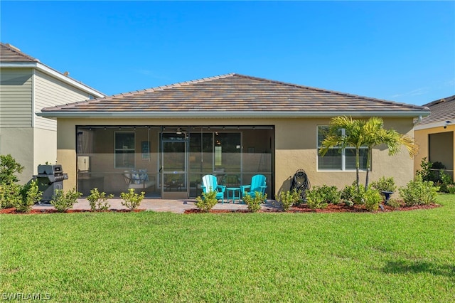 rear view of property with a yard and a sunroom