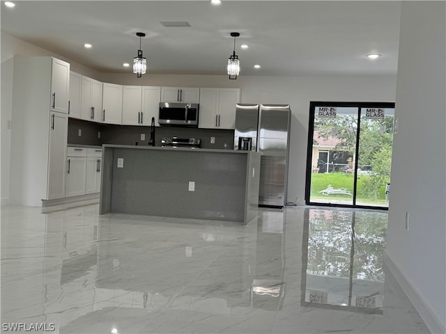 kitchen with light tile patterned flooring, stainless steel appliances, and pendant lighting