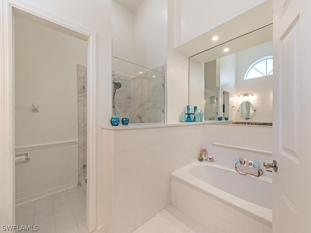 bathroom with tile patterned flooring and separate shower and tub