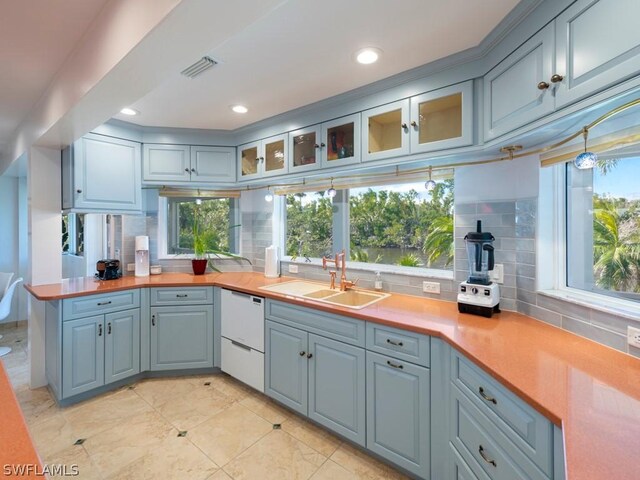 kitchen featuring white dishwasher, sink, butcher block countertops, and plenty of natural light