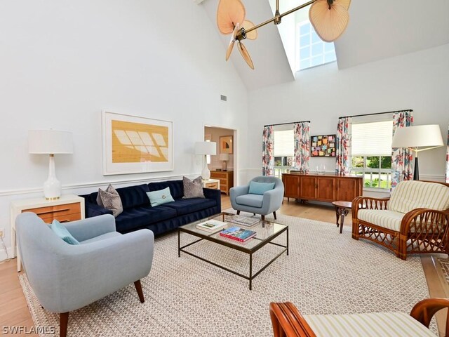 living room with light wood-type flooring and high vaulted ceiling