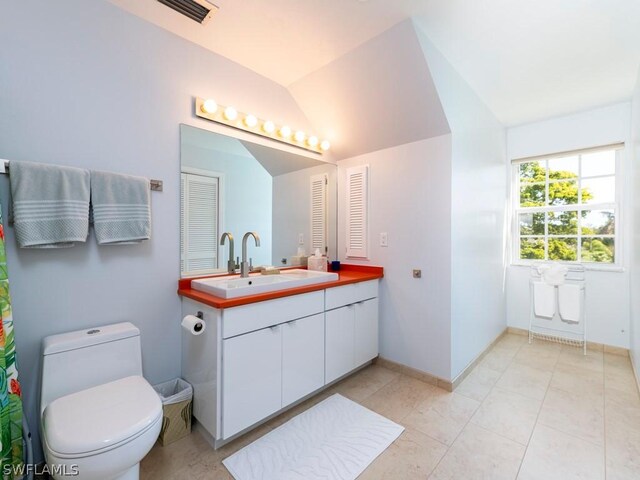 bathroom with vanity, vaulted ceiling, and toilet